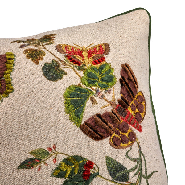 A rectangular cotton lumbar pillow with an embroidered butterfly and flower design on a beige mud cloth background, featuring green piping around the edges.